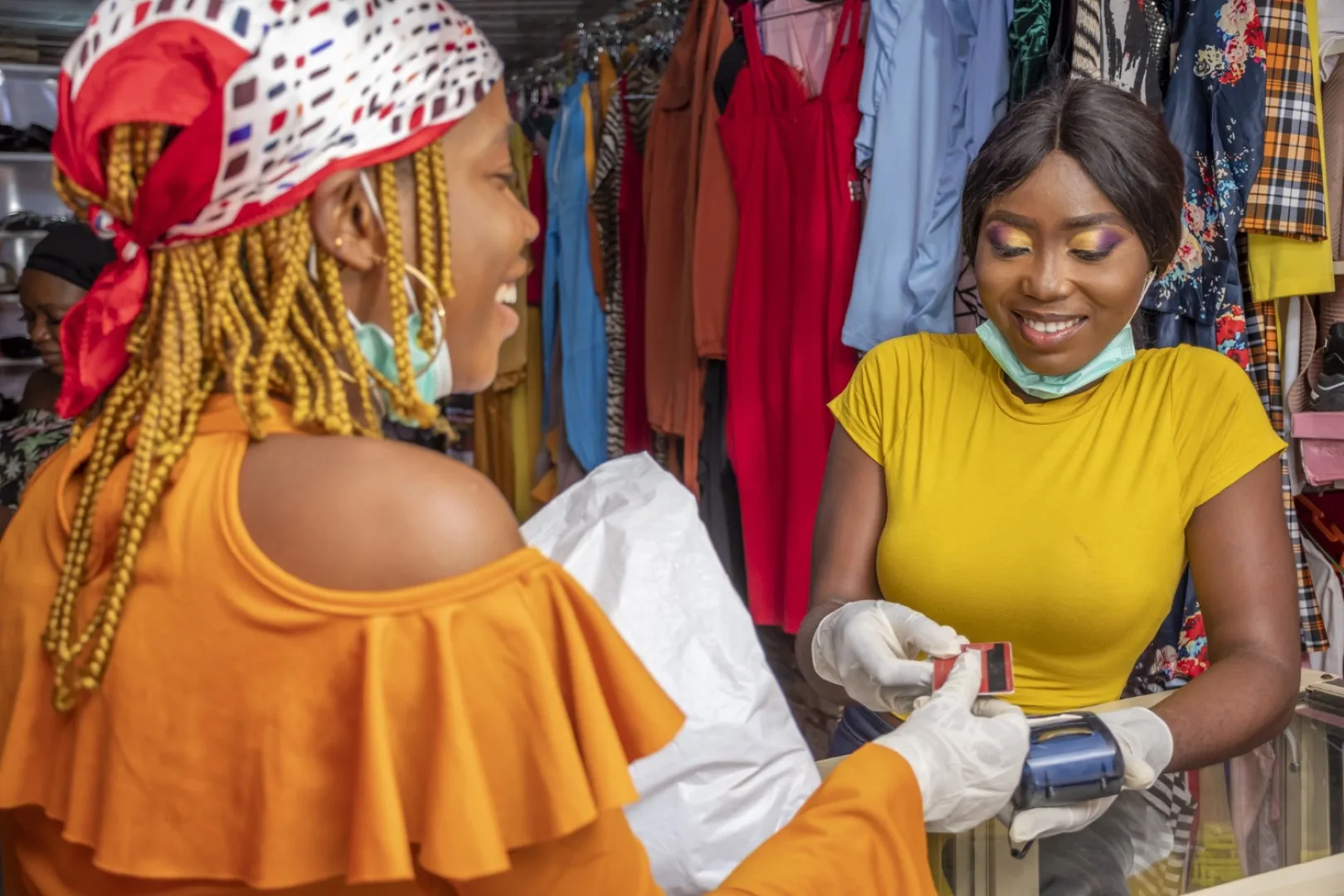 Women completing a transaction at a clothing business